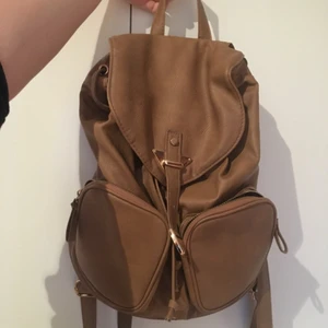  - Fin och trendig ryggsäck från Primark i London! Ryggan är lätt att matcha till allt och sitter skönt på ryggen :) snygga gulddetaljer också.  Eftersom jag har haft den i ca två år är den lite sliten på vissa ställen men detta syns inte tydligt alls!   Betalning via Swish! Möts upp i Stockholm eller så står köparen för frakt <3