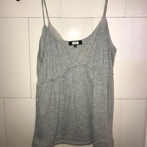 Grå topp. - Grå topp med spets detaljer vid brösten. Mycket skönt material. Sitter inte tajt! 65 kr med inkluderad frakt.