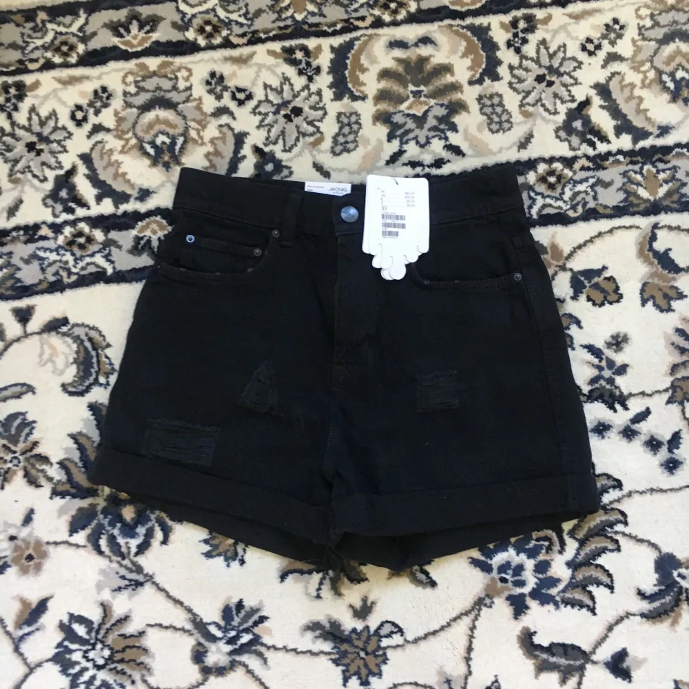 Svarta shorts med snygga slitningar på låren, från Monki i storlek xsmall. Höga i midjan. Aldrig använda.  Köparen står för ev frakt . Shorts.