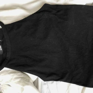  - Svart räfflad kroppad topp.