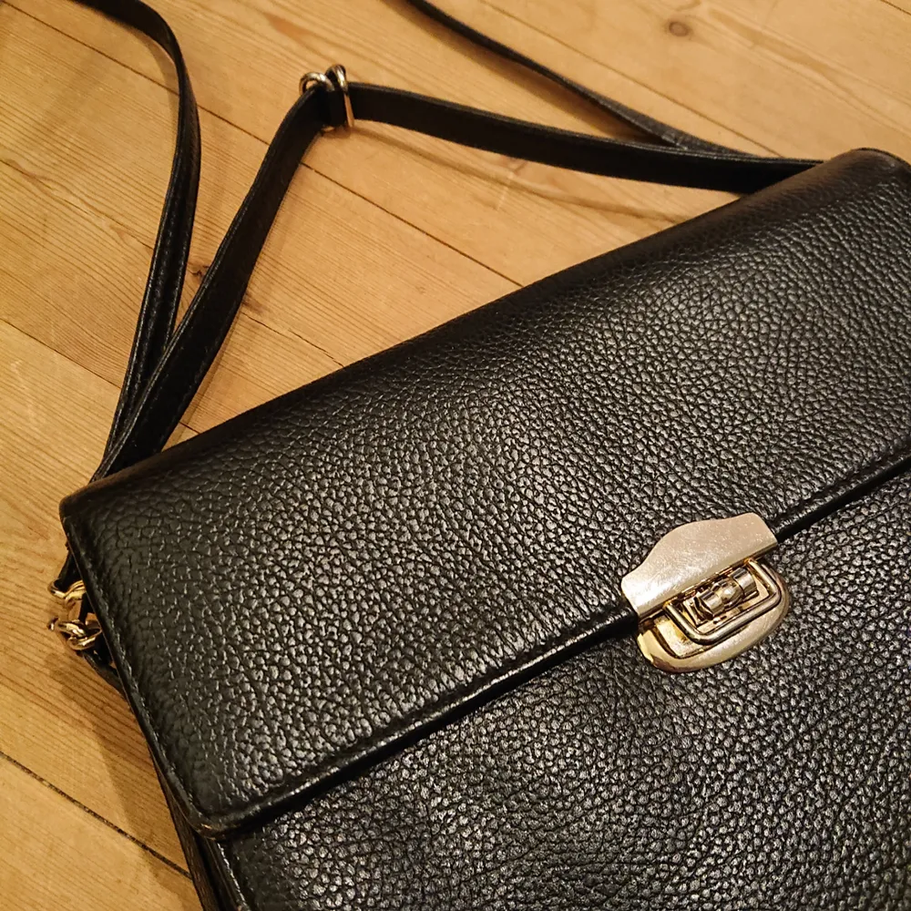 Vintage svart väska med silverdetaljer i fint skick! Någorlunda liten och smalt boxig i modellen, rymmer trots det ganska mycket! . Väskor.