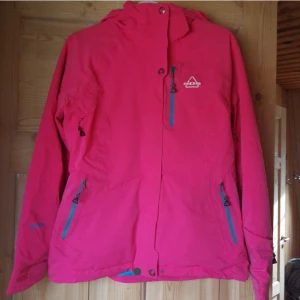  - Sjukt snygg skidjacka från sos, sportswear of sweden. Använd vid två skidresor. Snölås, snygga blåa detaljer på dragkedjor. Luvan går att vika in i kragen. Ventileringsmöjligheter under armarna. Ficka för skidkort på armen. Betalare står för frakt. Fler bilder kan skickas! 