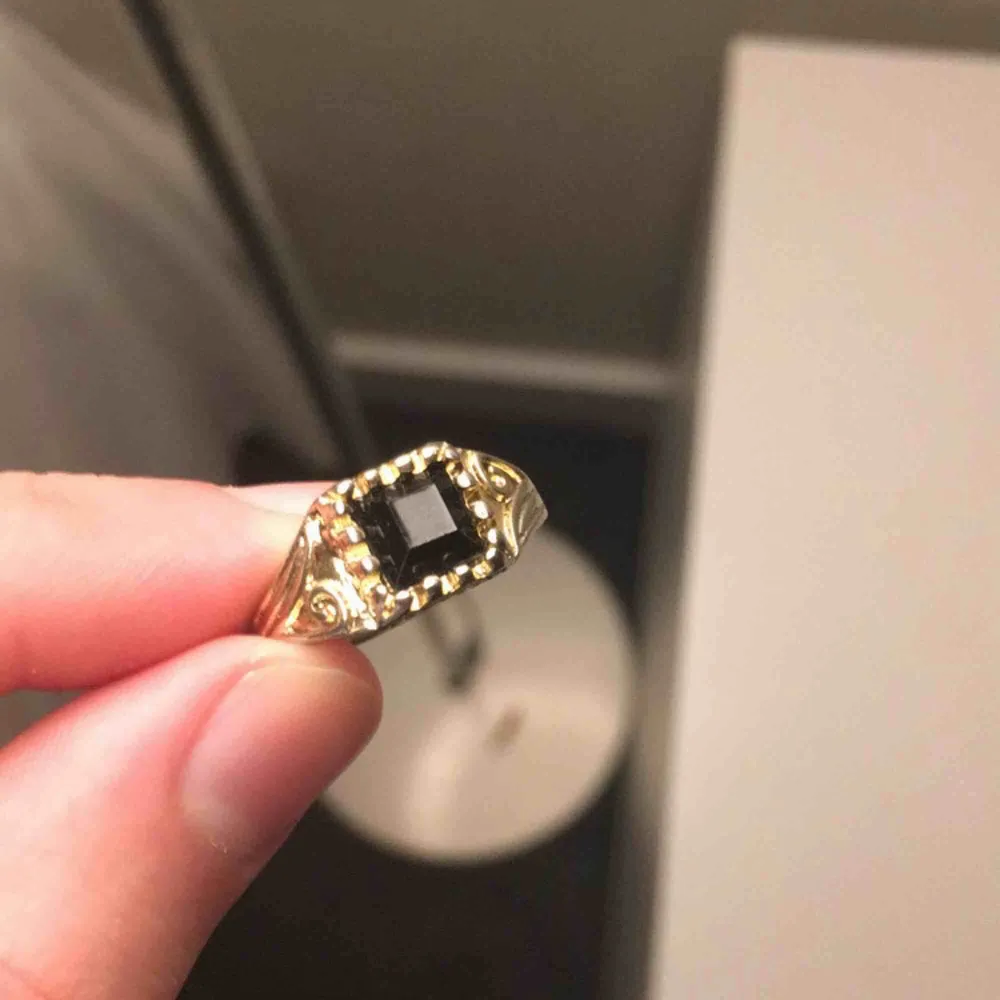 Guldfärgad ring med liten svart sten. Möts i Örebro eller skickar, köparen står för frakt. Accessoarer.