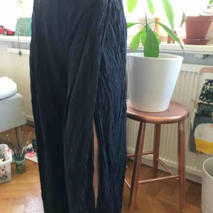  - Mörkblåa mjukisbyxor, de är slappa och sköna och har två slitsar vi benen. 