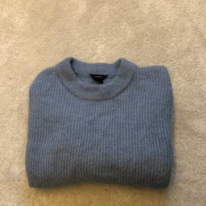 Mysig stickad tröja - Jättefin och mysig stickad tröja i en ljusblå färg. (Den verkliga färgen gör sig bäst på sista bilden) Knappt använd, därav jättebra kvalité. Säljer pga har inte fått användning för den. 