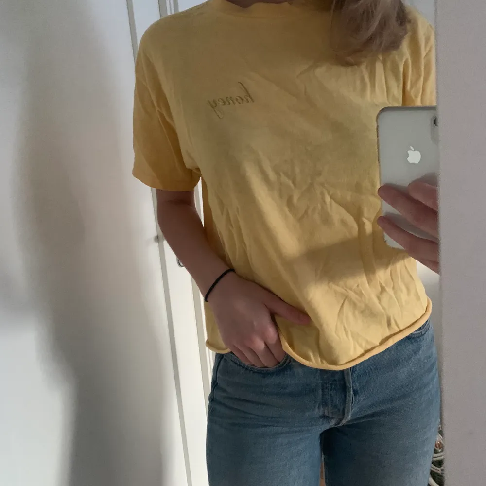 Gul T-shirt med trycket ”honey” från Brandy Melville, storleken står inte men passar nog xs-m beroende på hur man vill att den ska sitta.. T-shirts.