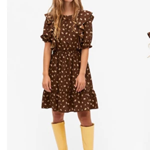 Säljer denna helt ny klänning för att den är fel storlek💕💕 - Brun med rosa fina blommor på med volanger