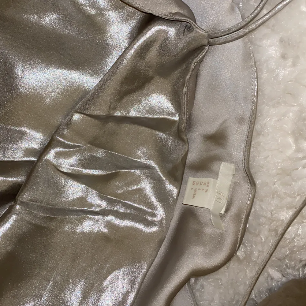 Miniklänning från H&M! Detaljer med metallictråd. Silver färg! Knäppning i sidan med dragkedja. Använda en gång!!!! Det ser ut som nytt! 🙂. Klänningar.