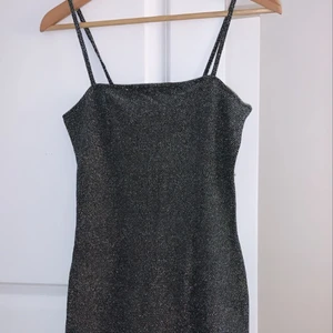 Glitter klänning  - Säljer denna klänningen som även har en slits vid benen, aldrig använd (prislapp finns kvar), passar perfekt till nyår! Kan fraktas. Den är S men passar även XS