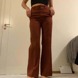 Kostymbyxor - Riktigt snygga kopparröda kostymbyxor med raka ben från Beyond Retro! Innersöm: 74 cm, midja: 72 cm, höft: 84 cm