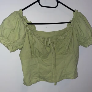 Singoalla top med puffärm o knyt detalj  - Singoalla top med puffärm och knyt detalj ovanför bröstet. Kort modell / magtröja, Limegrön. Aldrig använd 