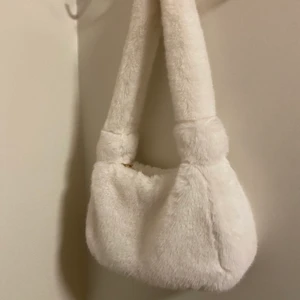 Pälsväska - Fin och mysig väska i fuskpäls💗☁️  Väskans mått: Höjd:15cm Bredd:30cm hela axelbandet är 66cm💫 Säljs  för samma pris den köptes för😌