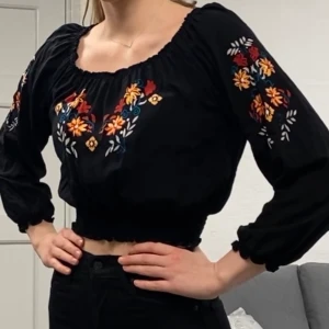 Kort topp med mönster - Fin pösig kort topp med resår i midjan, aldrig använd. Storlek 38, men skulle säga att den passar från 34-38 pga resår och pösig beroende på hur tajt man vill ha den.