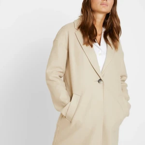 Topshop kappa - Beige Kappa från toppshop köpt från zalando där den nu är slutsåld. Helt oanvänd och i mycket bra skick,  köpt för nypris 779kr. Men säljs nu för 300kr. Kappan är i storlek 36 men är något stor i storleken