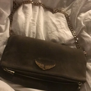 Zadigväska  - Säljer min zadigväska köpt här på plick! Väskan är i ett väldigt använt skick därav priset! De finns en liten fläck på baksidan av bläck men inget som stört mig!! Hör av er så berättar jag mer om skicket!! Startbud 250 eller köp direkt för 700