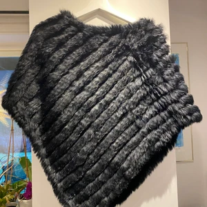 Pälskofta - En svart pälskofta som passar perfekt över kläder men även över jackor. Pälsen som den är gjord av är fake. Storleken är one sized. 