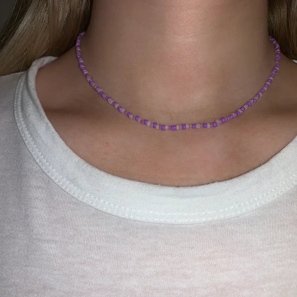 Lila pärlhalsband med små pärlor💜🤍⭐️🤩💫 halsbandet försluts med lås och tråden är elastisk . Accessoarer.