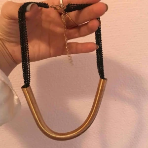  - Halsband, svarta kedjor och guld metall.  Mycket snygg med en bra vald klänning 