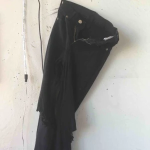  - Svarta jeans med slita knän från SALT