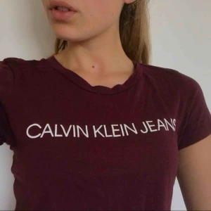  - Vinröd T-shirt från Calvin Klein. Bara använd 1 gång. Köparen står för frakten.