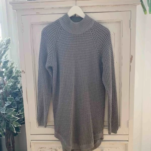  - Stickad klänning i en grå färg 