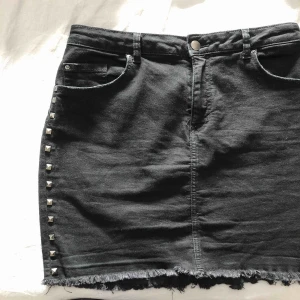  - Svart jeanskjol med silvriga nitar på sidorna i storlek 42, sitter dock som m/l. Aldrig använd💙💙🌟