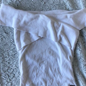 vitt linne - Ett vitt ribbat linne från holister. Omlott vid axlarna. Frakt tillkommer till priset. 