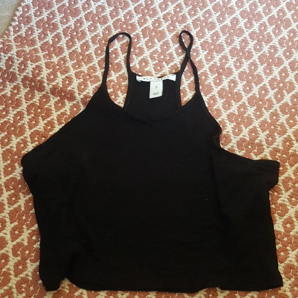 Ett svart cropped linne med boxarrygg från NLY TREND säljes då det aldrig har använts. Lite transparent. Passar även folk som brukar bära M.. Toppar.