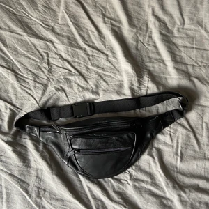 Svart midjeväska i fejk läder - Använd fåtal gånger så i mycket bra skick. Frakt tillkommer
