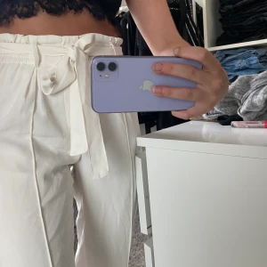 Vita vida byxor med knyte  - Vida byxor med knyte och sömdetalj längst båda benen. Byxorna är normallånga. Har en fläck på snöret! Köparen står för frakten🥰