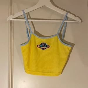 gul topp 🪐 - crop top med broderad liten planet på🪐🪐 Säljer billigt för att det ej är säsong just nu. aldrig använt, billig kvalitet 