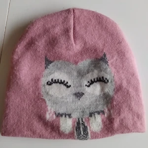 Söt rosa Kappahl mössa uggla 48/50 - Använd men i gott skick. Lite glitter detaljer på ugglan.