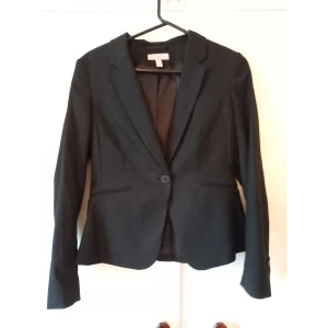 Kavaj H&M - En svart kavaj från H&M använd endast ett fåtal gånger. Snygg figur men lite för liten i ryggen för min del. Köpt för 300 kronor i våras. 