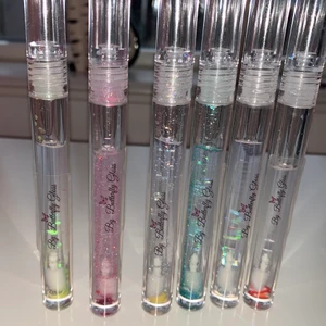 Läppglans - Säljer läppoljor som även går att beställa på min Instagram by_butterflygloss! Innehåller vitamin E olja, grapeseedoil och kokosolja för att mjukgöra läpparna. Jag har varit väldigt noggrann med hygienen vid produktionen av dessa: uppsatt hår, tvättade tuber, handskar och spritad yta etc! Läppoljan känns väldigt mjukt på läpparna. Alla luktar olika och finns i färgen clear. De luktar kokos, hubba bubba, strawberry/kiwi, polkagris, ananas, vanilj, citron och kostar 30kr st❤️ Säljer även läppoljor i mini för 20kr st. Gåva medföljer vid köp💕