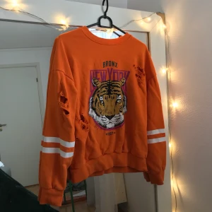 Gina tricot crewneck - Säljer denna tröja då jag tyvärr aldrig använder den längre. Den är från gina tricot och var väldigt eftertraktad förut. Cool orange färg och i bra skick (hålen ska vara där :)
