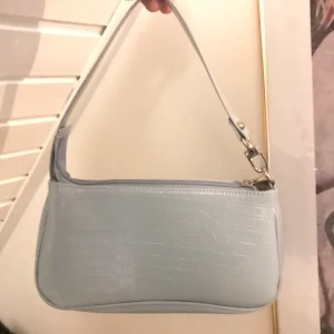 Ljusblå väska - Ljusblå väska. Krokodilmönster i glansigt material. Silver detaljer. Onesize. Andvänd en gång, nyskick. 125kr inkl frakt!!😍😍