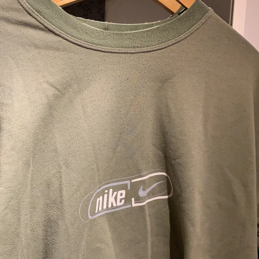 Super fin grön Nike tröja med vitt och grått tryck. Fint men använt skick då den är vintage:) storleken går inte att se då lappen är borttagen men troligtvis M i herr storlek . Hoodies.