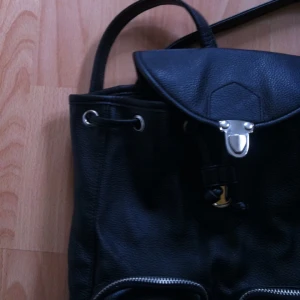  - ▪️Dösnygg ryggsäck i svart skinnimitation med silvriga detaljer & fina blixtlås▪️

• Storlek: Något mindre än ett A4
• Märke: MONKI
• Material: 100% Polyester
• Skick: Knappt använd, exemplariskt skick
• Övrigt: Inga skavanker alls
• Frakt: 42-49kr