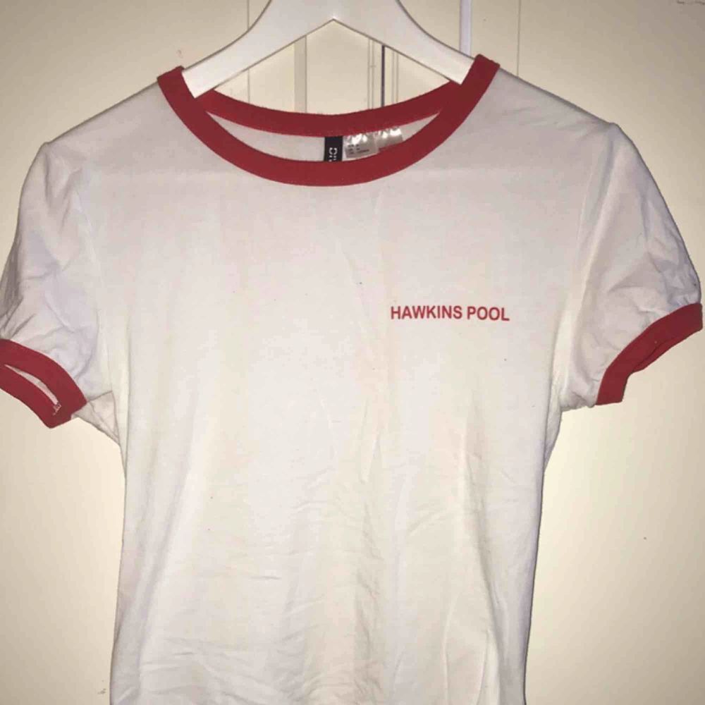 En vit T-shirt med röda ärmar och krage från H&M med tema från Stranger Things🔦. Sparsamt använd och i bra skick. Tröjor & Koftor.