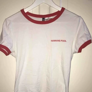  - En vit T-shirt med röda ärmar och krage från H&M med tema från Stranger Things🔦. Sparsamt använd och i bra skick