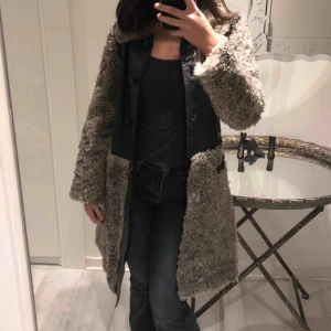  - En grå kappa med hår får liknande detaljer runt jackan. Jackan är använd men är i bra skick.  Säljs pga ingen användning.  