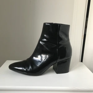 Svarta lack-boots  - Svarta lack-boots i strl 38 från ASOS! Använda fåtal gånger, inga repor i lacken elr liknande. Jättefina till när man ska klä upp sig, har alltid fått komplimanger för dom när jag haft dom på mig🥰 möts upp i Sthlm annars tillkommer frakt🥰