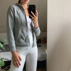 Grå zip-hoodie från Nike - En fin Nike-hoodie med dragkedja där fram. Lite kort i armarna för mig (Jag är 170) och det är därför jag säljer den. Det är en L i barn så sitter ungefär som en Xs fast sitter bättre på någon som är lite kortare än jag. I nyskick då den knappt är använd.