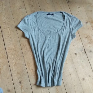 Grå tricot med puff ärm. - Puffad ärm o snygg fåll i ärm o I halsen. Urringad t-shirt I M. 