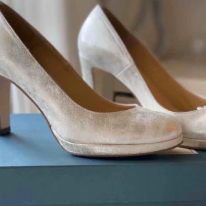  - Pumps i silver/ vita använda en gång på bal, nypris är 899 kr. Har en klack och år mjuka i sulan 