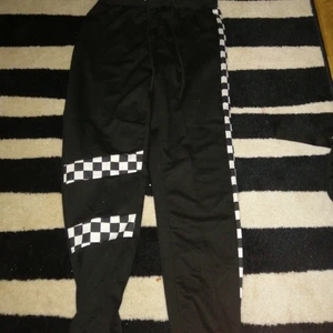  -  10Ett par mjukisbyxor i svart med rutmönster i vitt, använt 1 gong, annars helt ny
