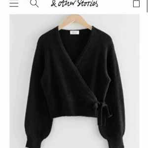  - Svart stickad tröja som går omlott