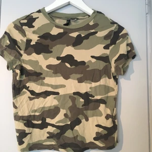 Kamouflage t-shirt - En grön kamouflage t-shirt från H&M som bara är använd ett fåtal gånger,köparen står för frakt (pris kan diskuteras)