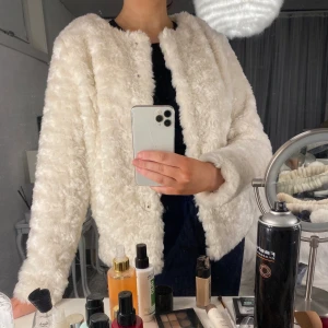 Vit jacka med fuskpäls - En vit jacka med fuskpäls som är skön och len. Rak modell med två fickor framtill. I storlek S och säljs just nu för 100kr inkl frakt🌸 Aldrig använd!