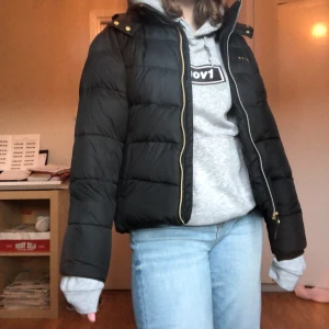 Vinterjacka - Säljer denna svarta vinterjacka för att den är lite liten, fint skick då den inte är använd så mycket. Guldiga kedjor och andra detaljer. Jackan har avtagbar luva och en päls som går att sätta på luvan, men som jag nu har tagit bort. Str 158-164 men skulle säga att de är en xs💖för mer frågor skriv privat🤑